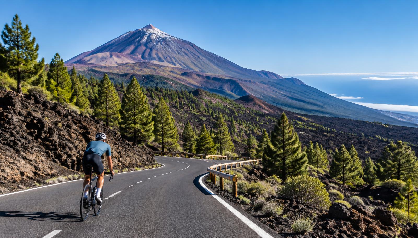 A cyclist riding towards Mount Teide through Tenerife's volcanic landscape
